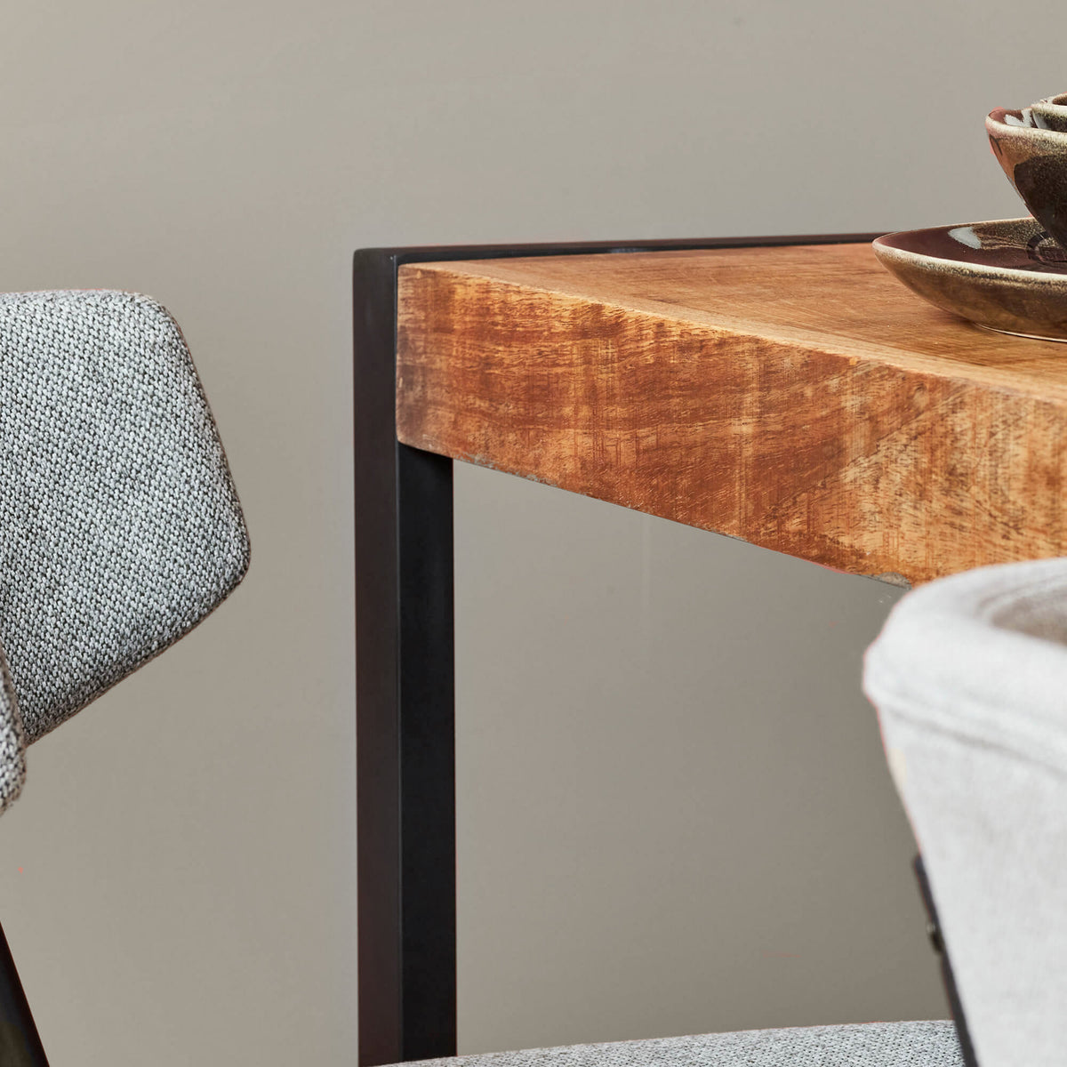 Eettafel met warmbruin houtnerf blad en zwarte metalen zijpoot, randdetail