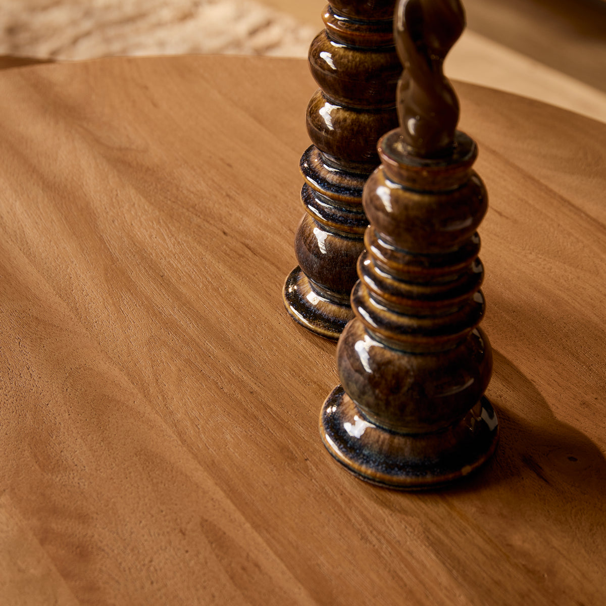 Houten salontafel met kaarsenstandaarden op rond blad.
