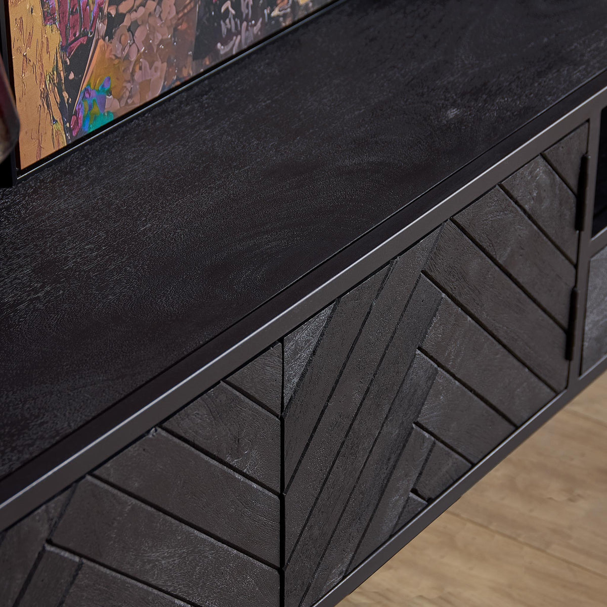 Zwevend tv-meubel: herringbone paneel en donkere frontbalk met decoratieve ruitvormige lijnen.