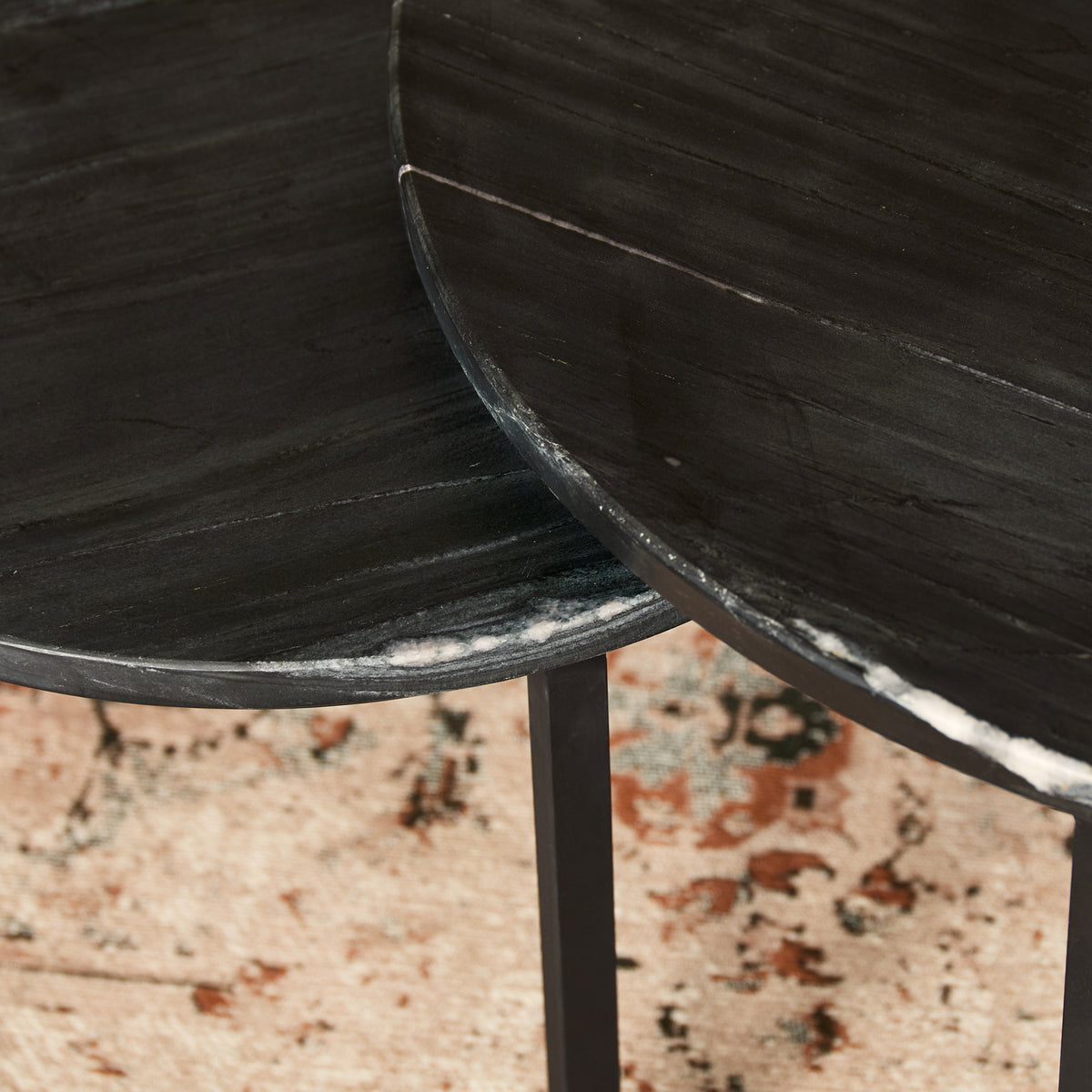 Ronde zwarte marmerlook salontafel met zichtbare rand en poot, met lichte nerf