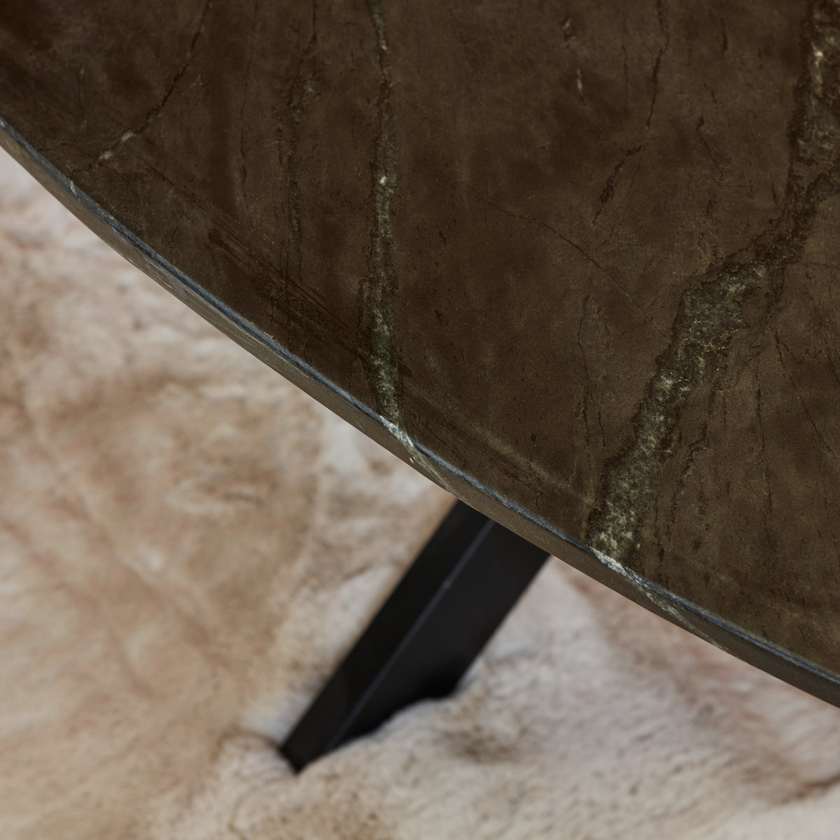 Ovale salontafelrand met zwart marmerlook en zwarte metalen poot.