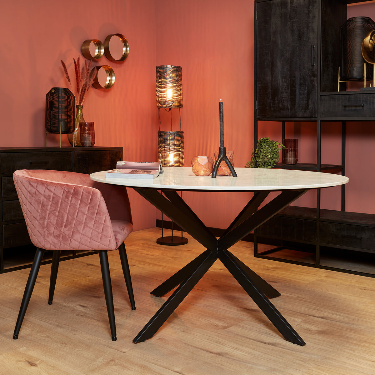 Ronde eetkamertafel met wit marmeren blad en zwart X-pootonderstel.