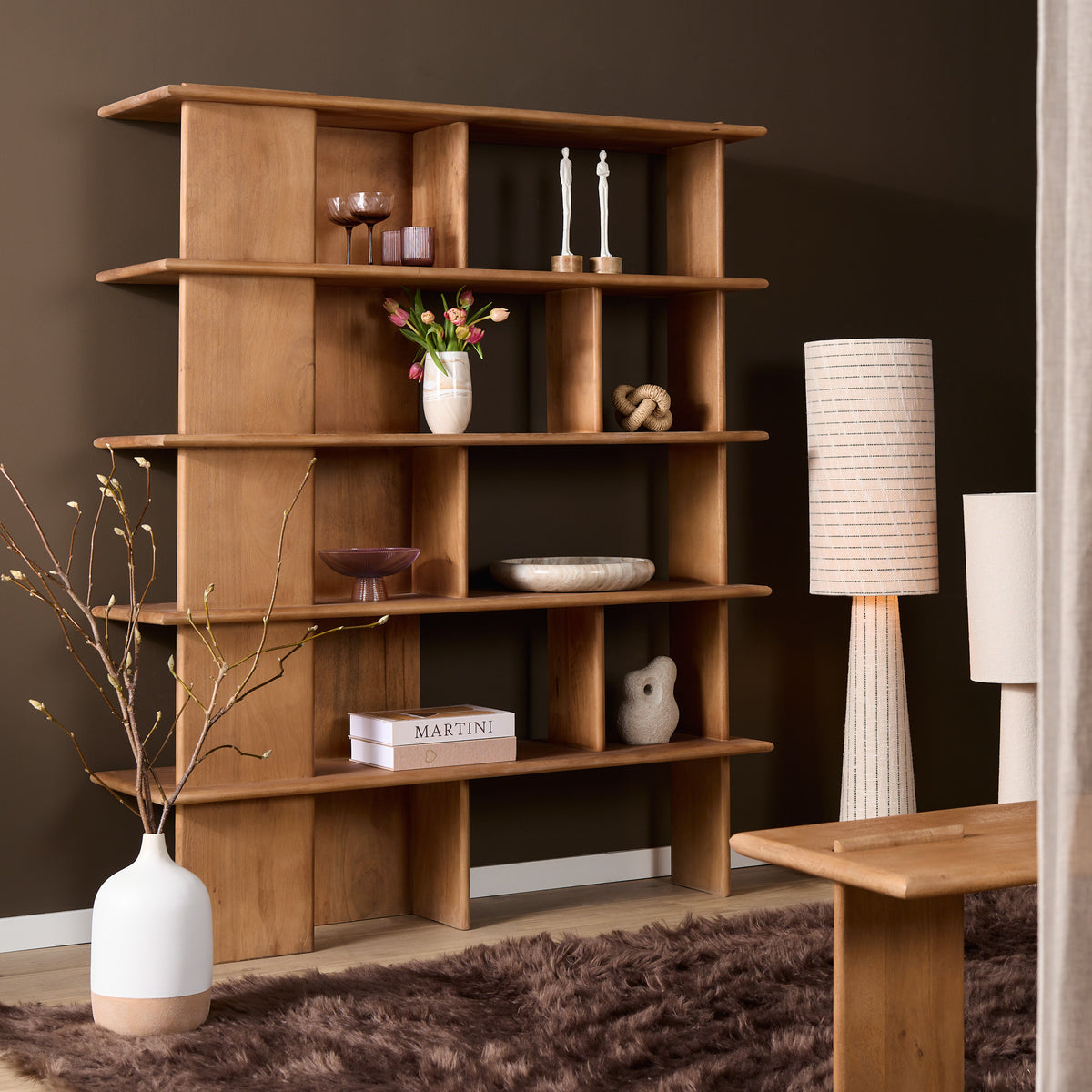 Wandkast met open vakken en legplanken, ingericht met decoratie zoals bloemen en accessoires.