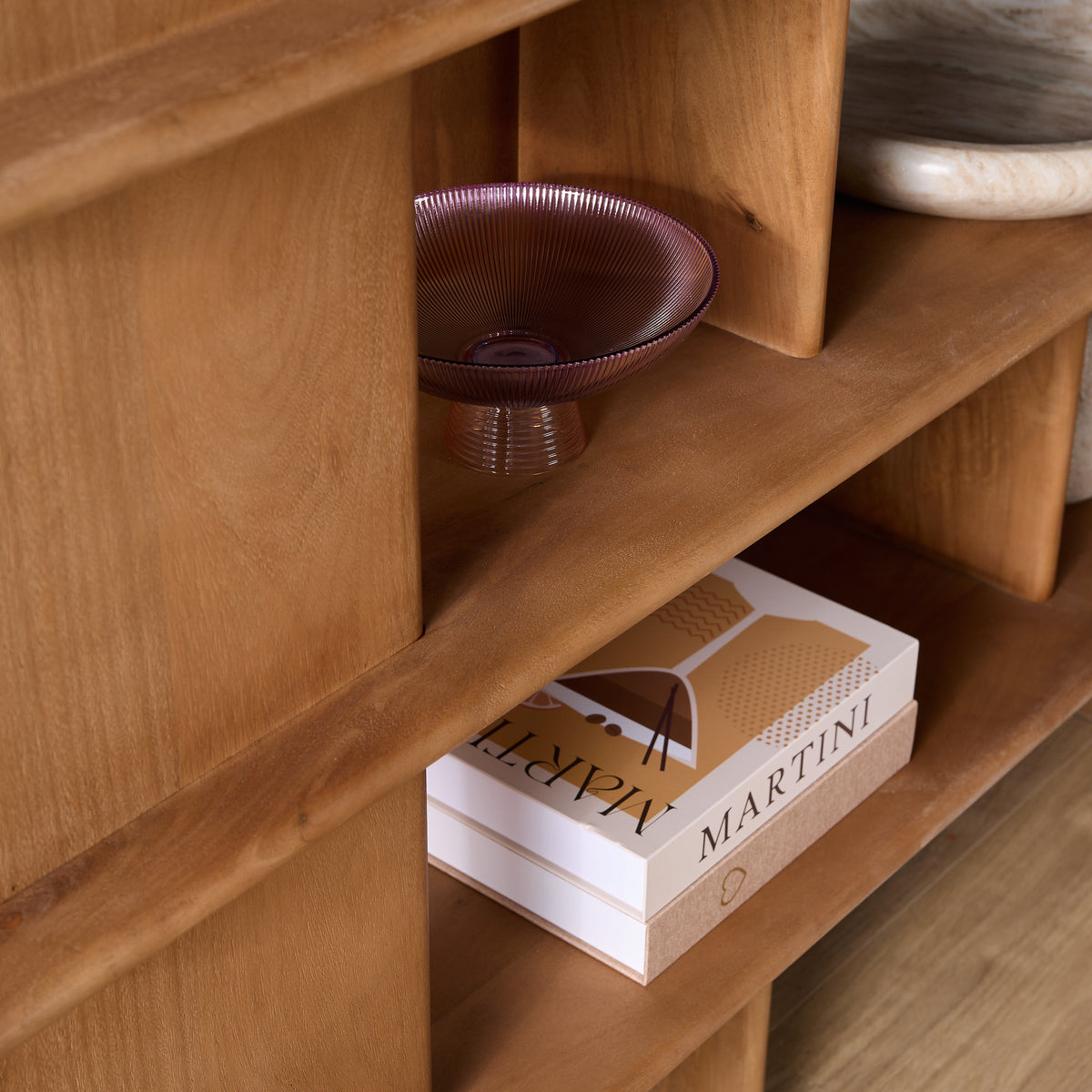 Wandkast nis met mandje en stapel boeken/doosjes op een houten legplank.