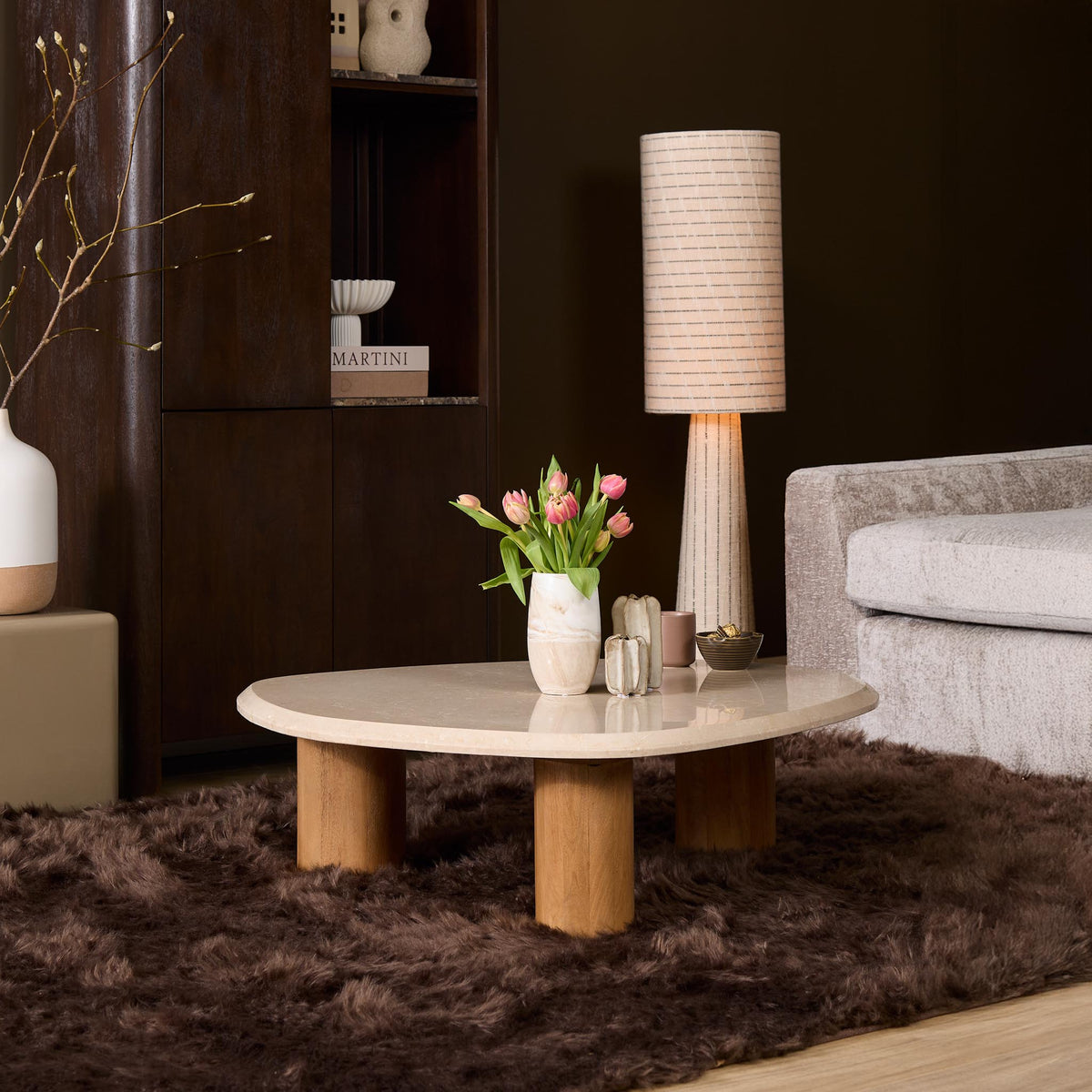 Ronde salontafel met licht marmerlook blad en houten poten.