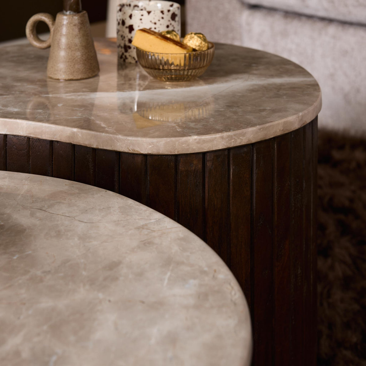 Salontafel met marmerlook blad en donkerhouten ribben, close-up van de rand