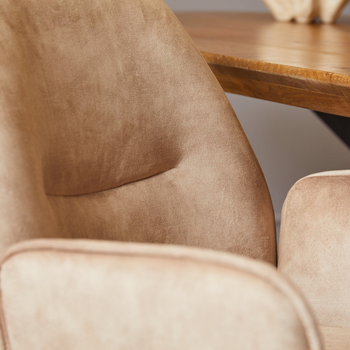Beige stoelbekleding met gestikte naden en afgeronde armleuning