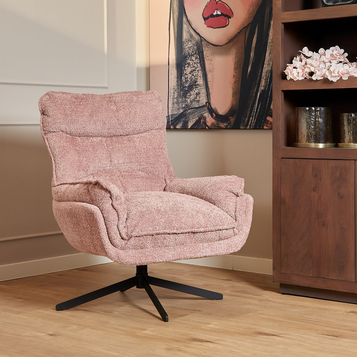 Roze fauteuil Vera met gewatteerde rug, brede armleuningen en zwarte draaivoet.