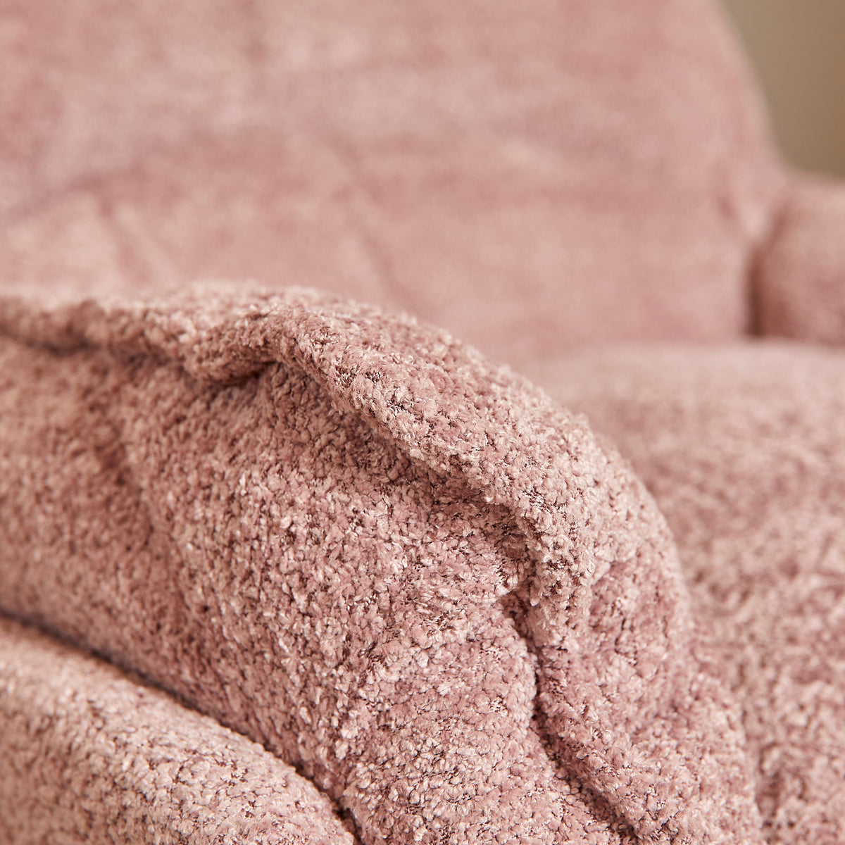 Roze armleuning en rimpeldetail; gebogen vorm met zichtbare stiknaden.
