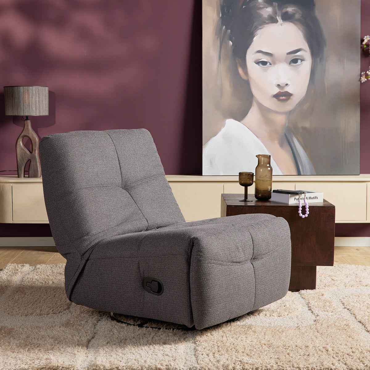 Donkergrijze relaxfauteuil met hoge rug en uitschuifbare voetensteun, ronde voet.