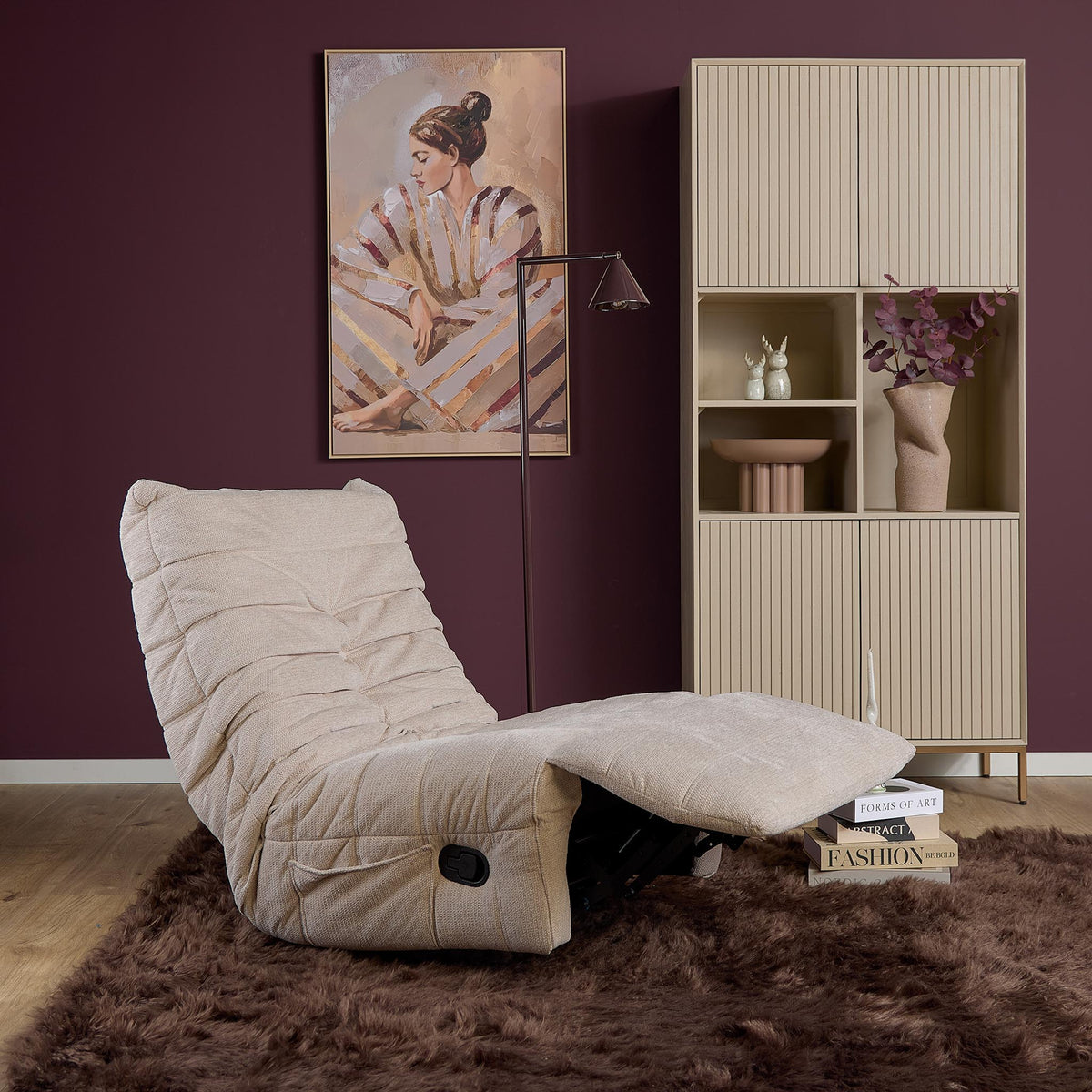 Beige relaxfauteuil met voetensteun, schuine zijaanzicht en ronde zwarte bedieningsknop