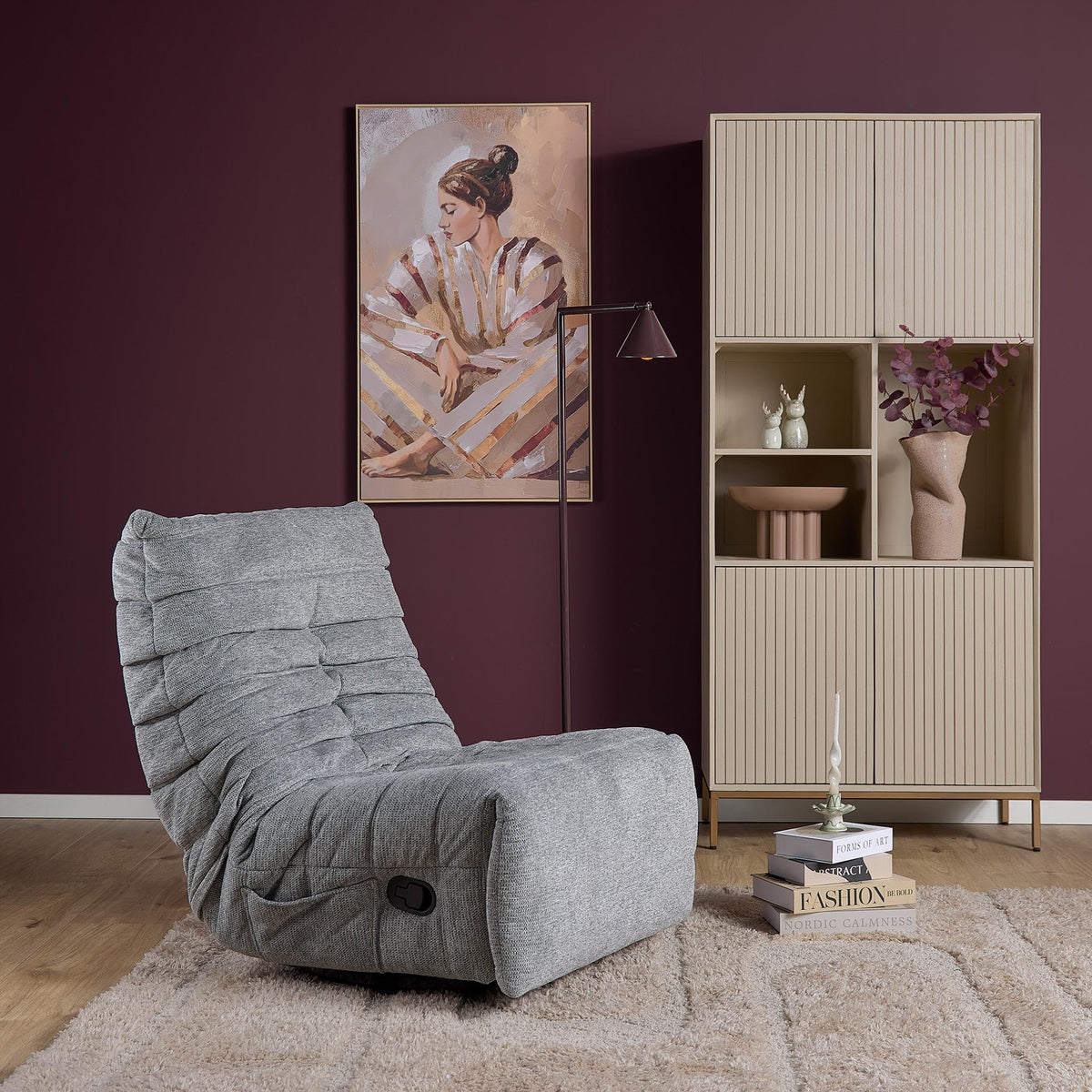 Grijze relaxfauteuil met schuine rugleuning en voetensteun in open stand.