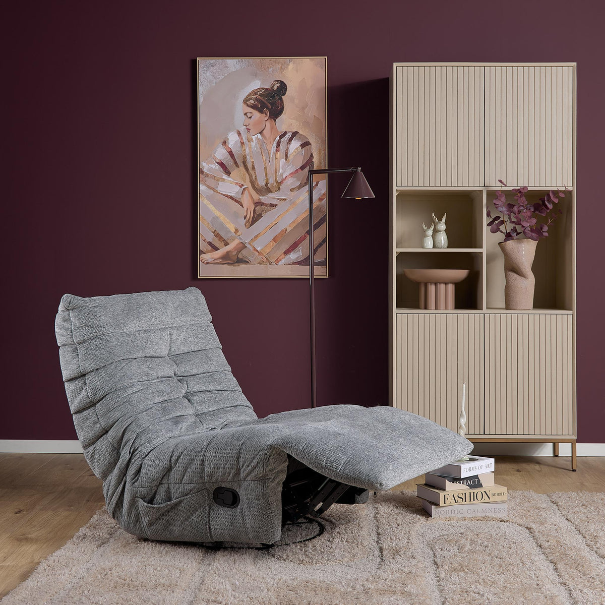 Grijze relaxfauteuil met verlengde zitting en zwarte bedieningsknop aan de zijkant.