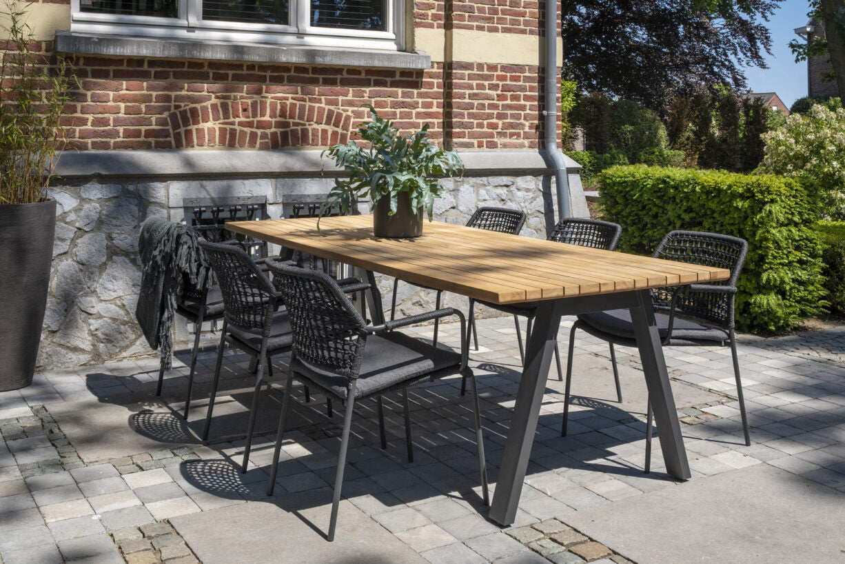 Antraciet set diningstoelen met kussens en gevlochten rug rond tafel