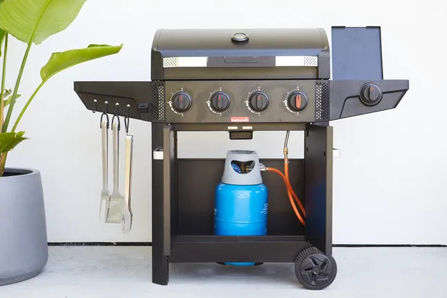 Zwart gasbarbecue met open deksel en zijplank; binnen opbergplank met accessoires