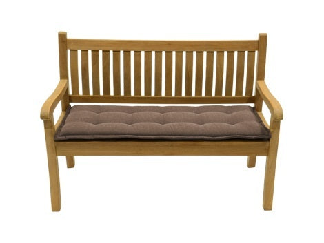 Taupe bankkussen met quiltstiksels, liggend op een houten bankje.