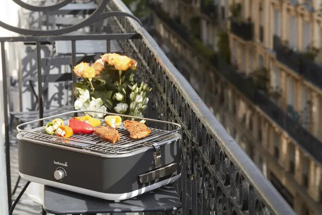 Elektrische tafelgrill met donkergrijze kast en grillrooster met gegrild vlees
