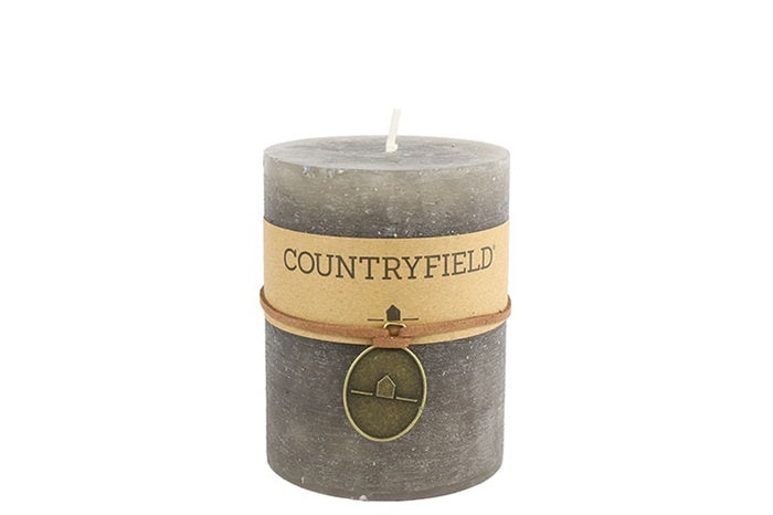 Grijze Countryfield kaars, effen cilindervorm met bruin label en decorhanger.
