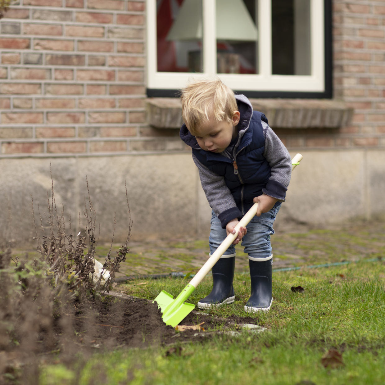 Kinder schep met houten steel en groen schepblad.