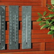 Leisteen thermometers op houten gevel, met Celsius- en Fahrenheit-schaal