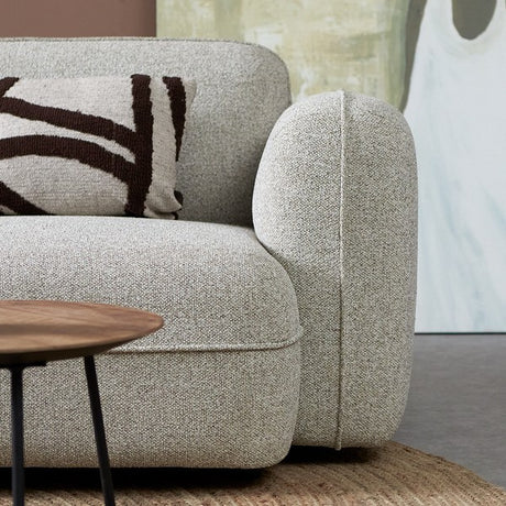 Lichtgrijze chaise longue met gewatteerde armleuning en bruine sierkussenhoes