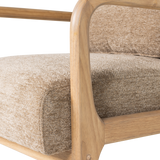 Zandkleurige chenille fauteuil met houten armleuning en volumineus zitkussen.
