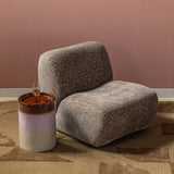 Fauteuil met craquelé velvet in lichtbruin, zijaanzicht met afgeronde rug en zitting.