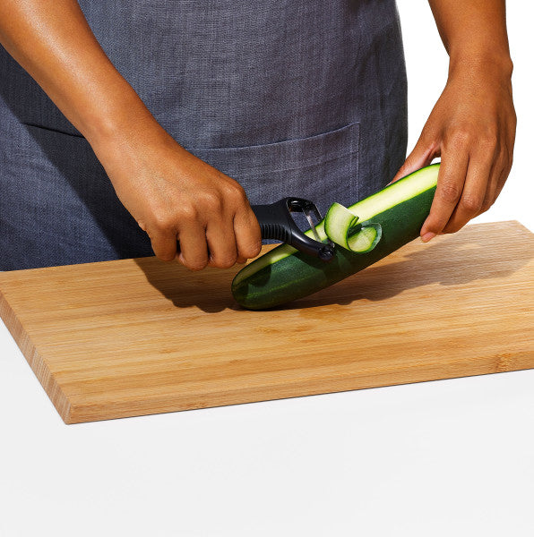OXO dunschiller Y-model in gebruik op komkommer op houten snijplank