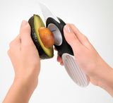 Avocadosnijder 3-in-1 in gebruik: avocado met zwarte greep en witte inzet.