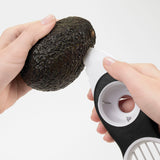Avocadosnijder 3-in-1 met ronde schijf met gat en witte snijpunten.