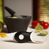 Avocadosnijder 3-in-1 op tafel met zwarte handgreep en witte snij-opzet.