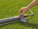 Gardena zwenksproeier met rood-blauwe knoppen, aangesloten op slang