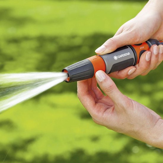 GARDENA tuinsproeipistool oranje-grijs met waterstraal uit sproeikop.