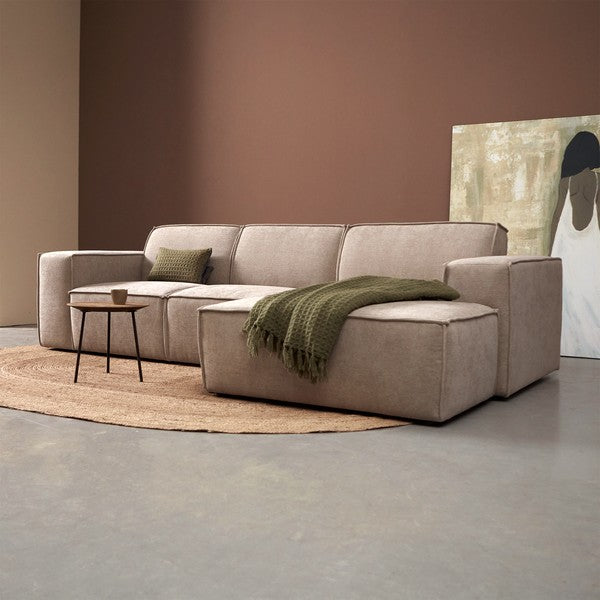 Chaise longue met lichtbeige stoffering en groen plaid op de lounge-ottoman