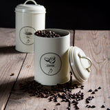 Voorraadblik koffie crème met open deksel en koffiebonen; etiket “COFFEE”