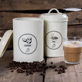 Voorraadblikken crème met etiketten koffie en thee, met koffiebonen op de voorgrond