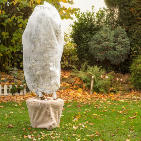 Wit wintervlies over plantenkap met koord, voor bescherming van tuinplanten