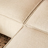 Beige divanbekleding met zichtbare stiknaden en geweven structuur, hoekdetail