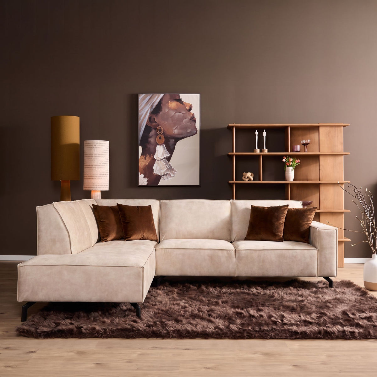 Beige fluwelen divanbank links met 2,5-zits, brede armleuningen en sierkussens