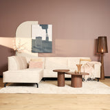 Beige fluwelen hoekbank met chaise links, lage poten en kussens op de zit
