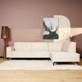 Beige fluwelen hoekbank met chaise rechts, meerdere sierkussens en losse chaise-zitting