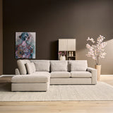Beige hoekbank met losse ottomaan rechts en meerdere rugkussens