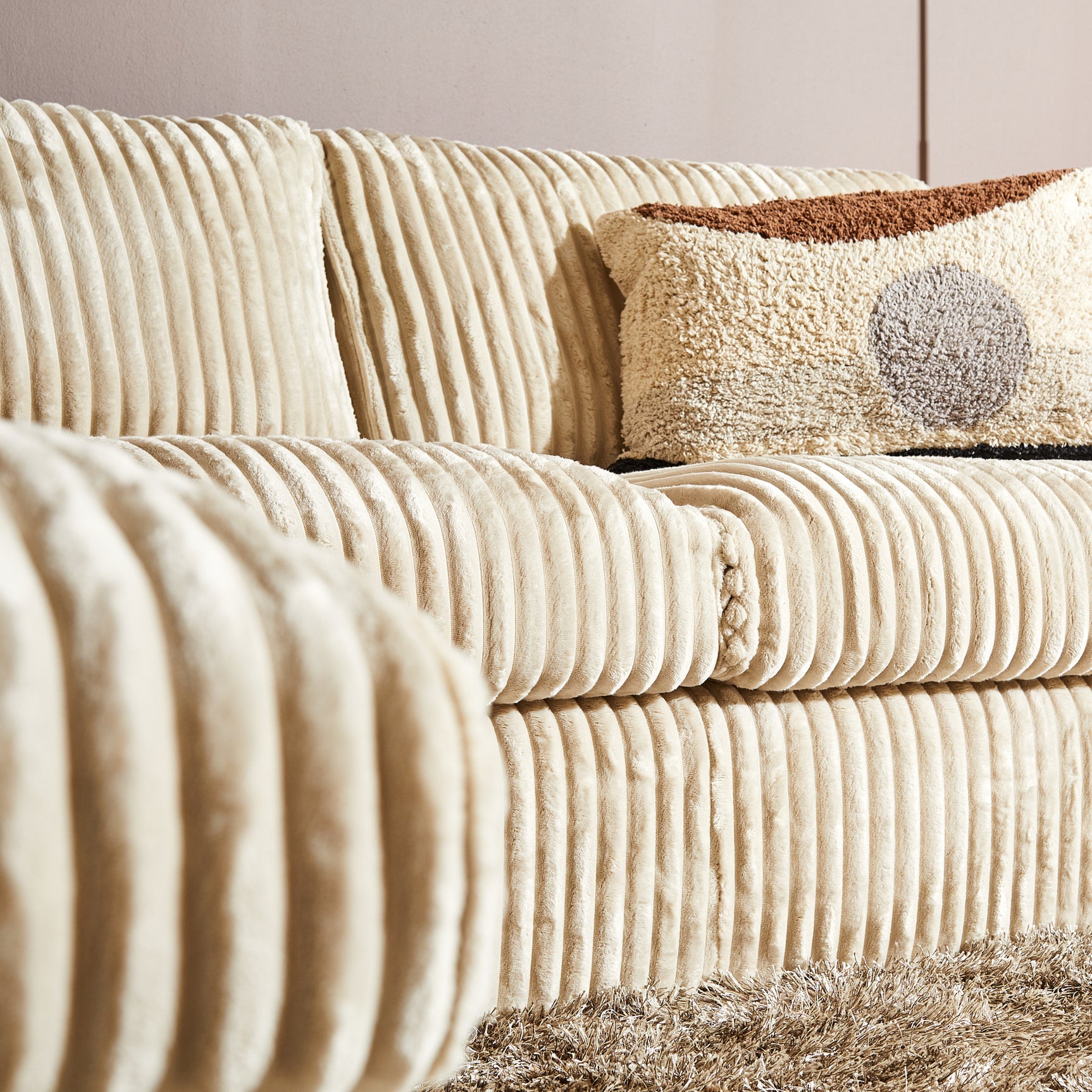 Beige Teddy bank met ribstructuur op zitting en arm, met sierkussen