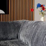 Antraciet teddy-bank met grote ronde rugkussens en divan-zijde.