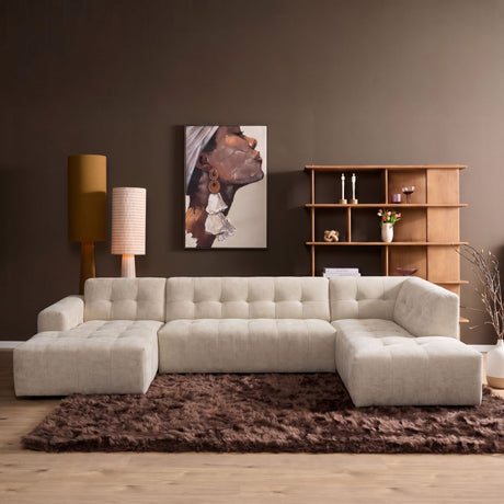 Beige hoekbank met losse ottoman rechts en hoge rugkussens, bekleed met stof