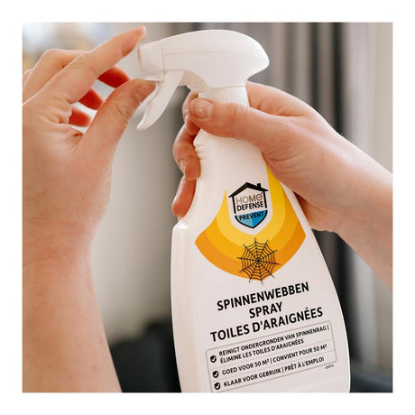 Spinnenwebben-spray in witte fles met spuitkop, in gebruik door twee handen