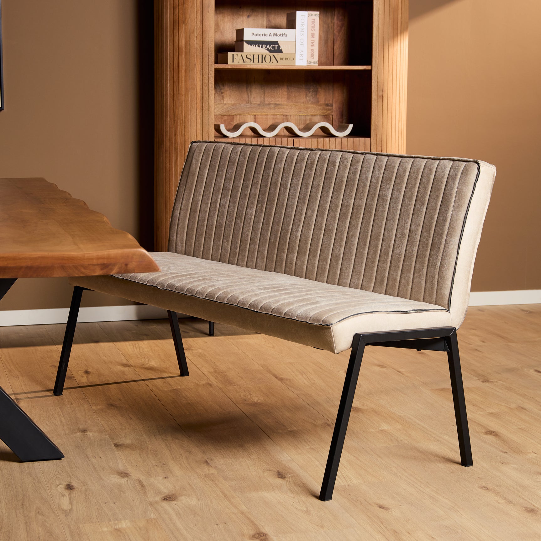 Beige gestoffeerde eetkamerbank met hoge rug en ribbels, zwarte poten
