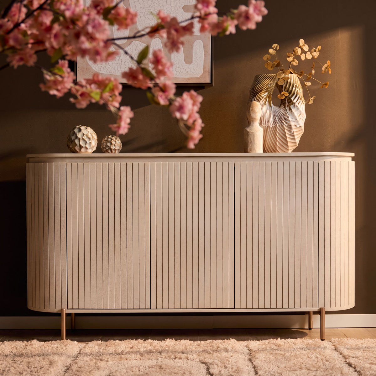 Dressoir met geribbelde witte frontpanelen en decoratie op de ronde bovenkant