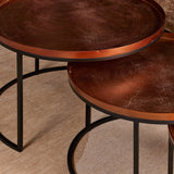 Ronde salontafelbladen met bruin houtnerf en zwarte metalen poten, close-up