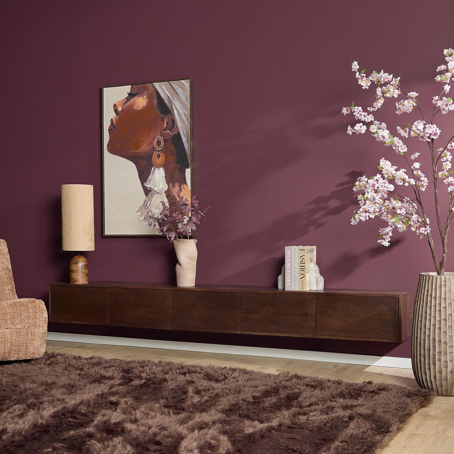 Zwevend tv-meubel bruin hout met ladefronten, met boeken en decoratie op blad